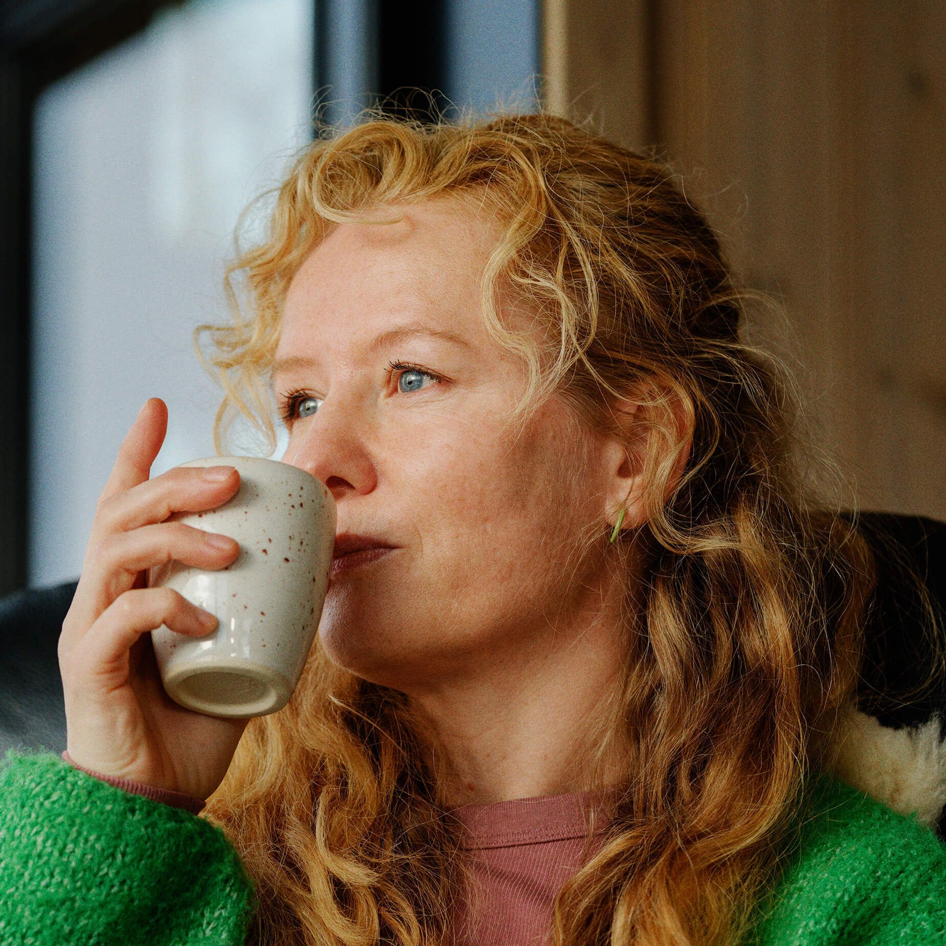 Kvinne med kaffekopp som har mobilabonnement fra Telenor