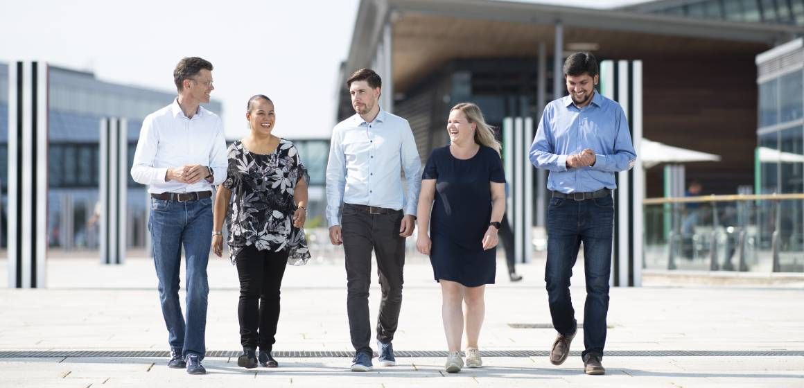 Petter-Børre og studenter går side ved side på ute på Telenors campus