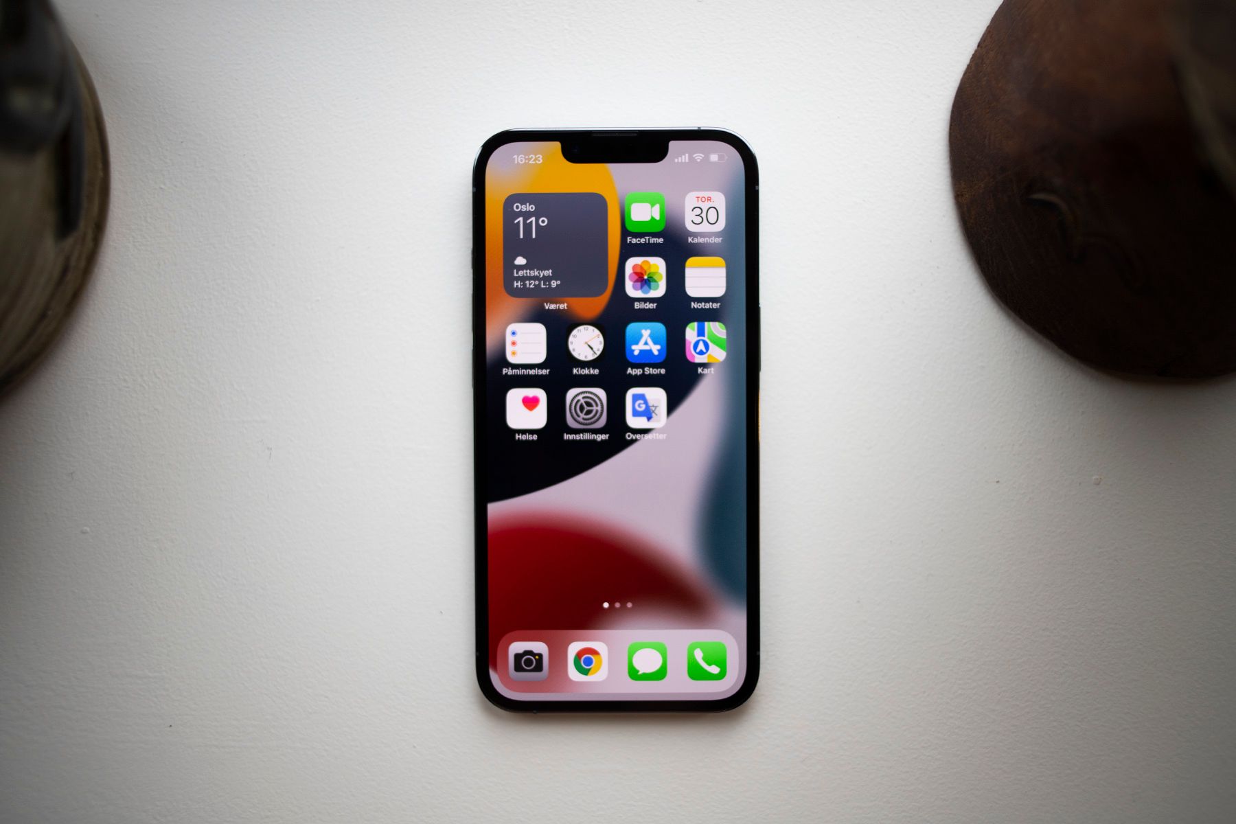 Bilde av iPhone 13 som ligger på et bord.