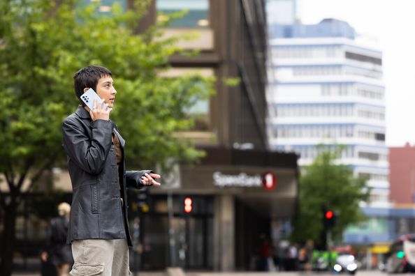 Kvinne som snakker i telefonen, glad fordi hun har tjenesten Nummervarsel inkludert i mobilabonnementet fra Telenor