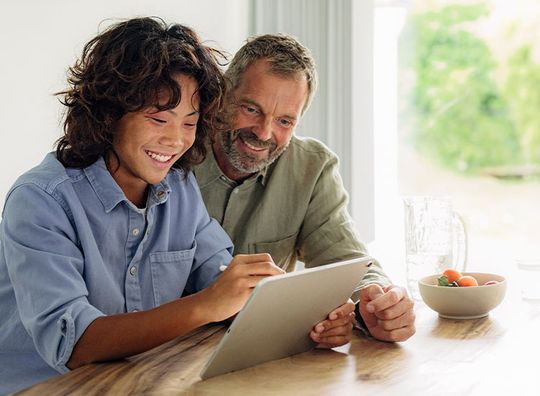 Gutt viser mann noe på en ipad
