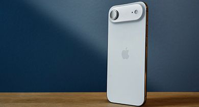 apple iphone air i fargen hvit på et trebord med blå vegg i bakgrunnen