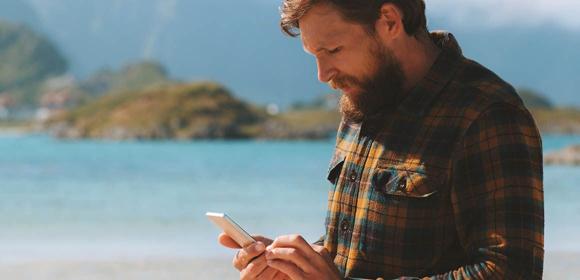 Mann med mobiltelefon i hånda