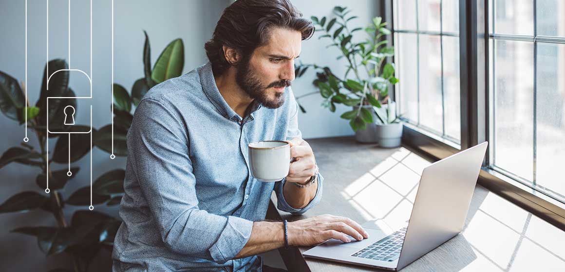 mann ser på pc og drikker kaffe