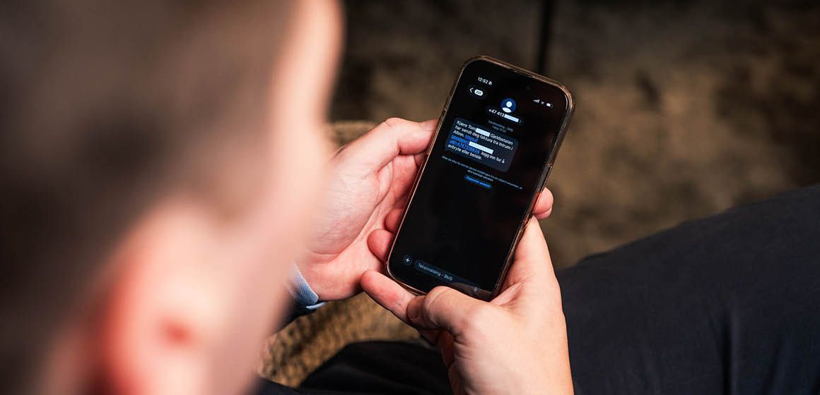 En person ser på en melding på en smarttelefon