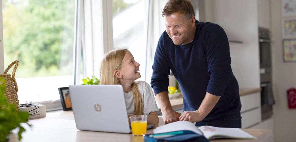 Far og datter med PC på kjøkkenet