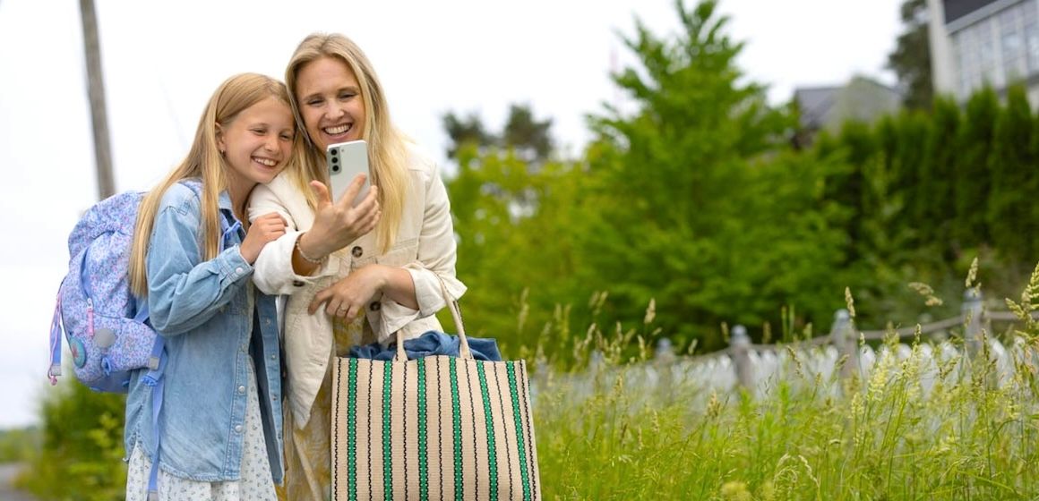 Mor og datter bruker mobildata på en varm sommerdag