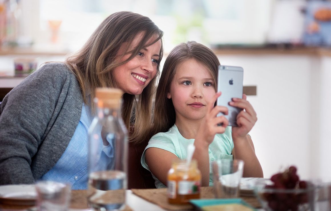 Mor og datter ser på en telefon sammen