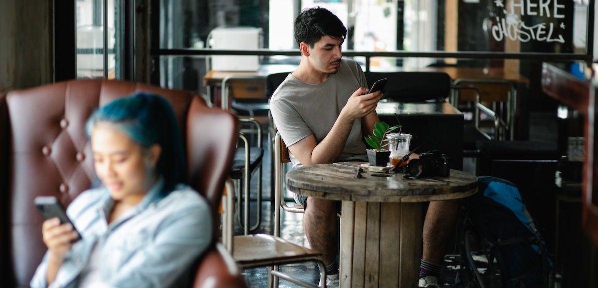 Mann og kvinne på kafé surfer på trådløst nett