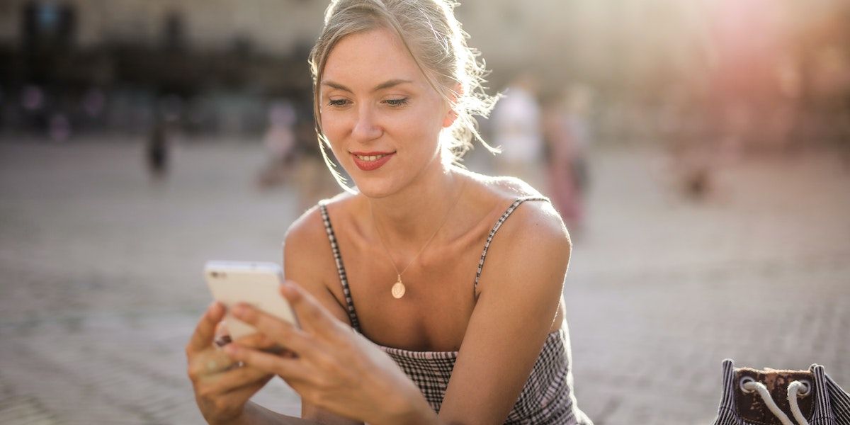 Kvinne med mobil nyter en perfekt mobilsommer