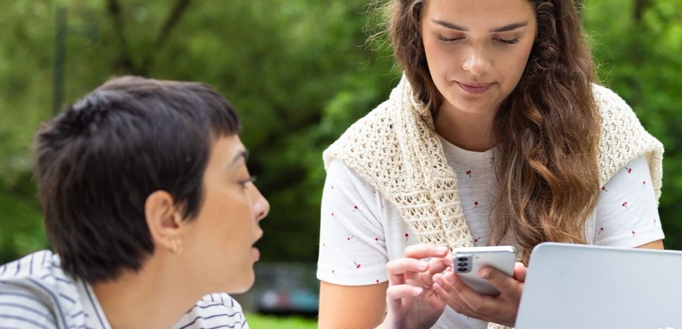 Telenor-dekning: To personer i parken med mobil og pc.