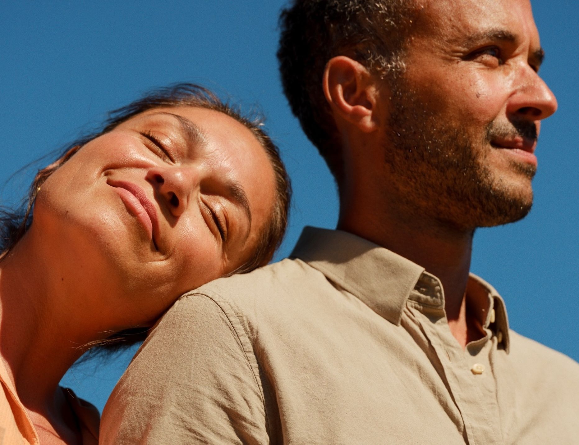 To personer i lyse klær under blå himmel