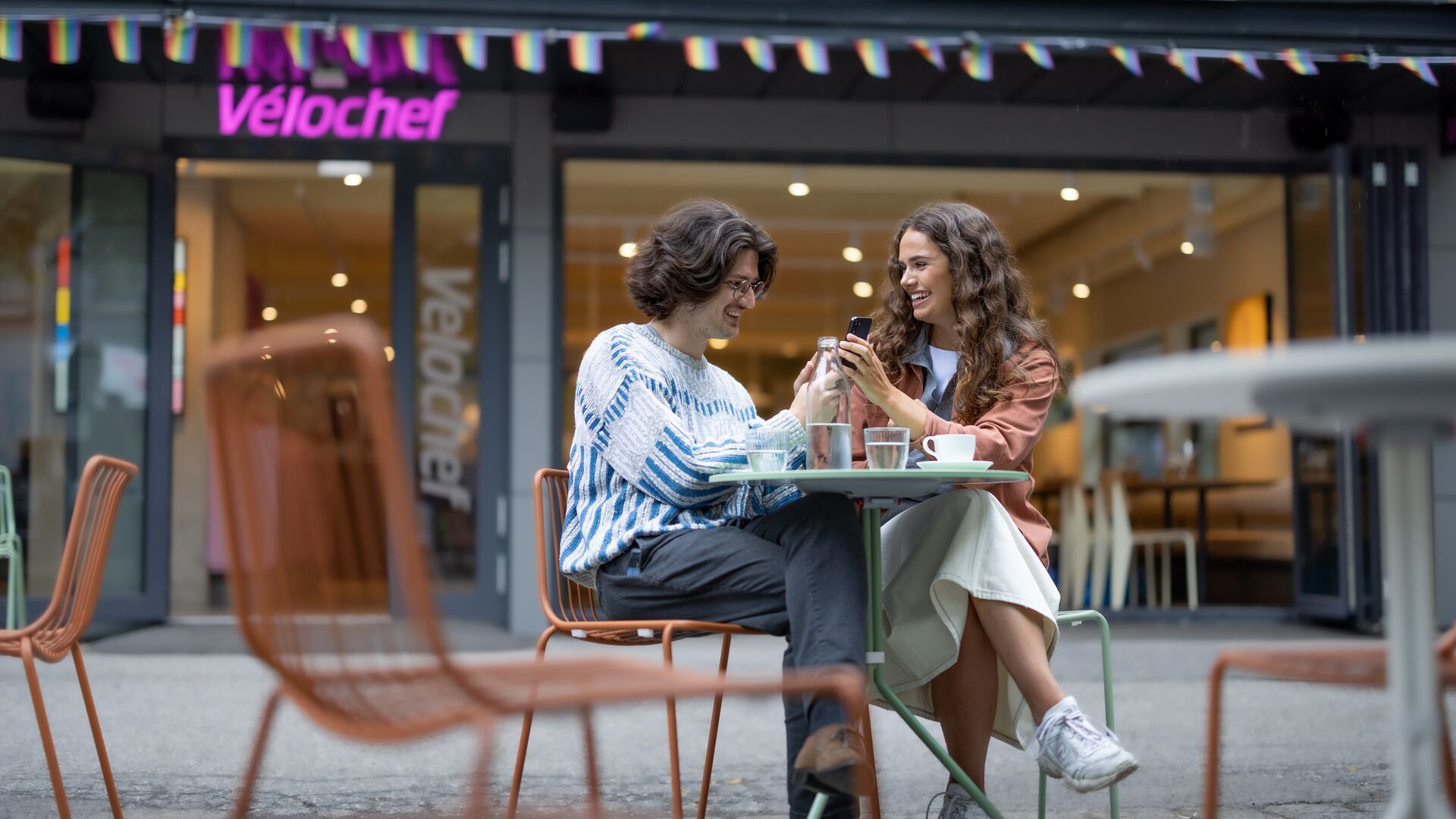 Et par på uterestaurant som kjøper datapakker på mobilen