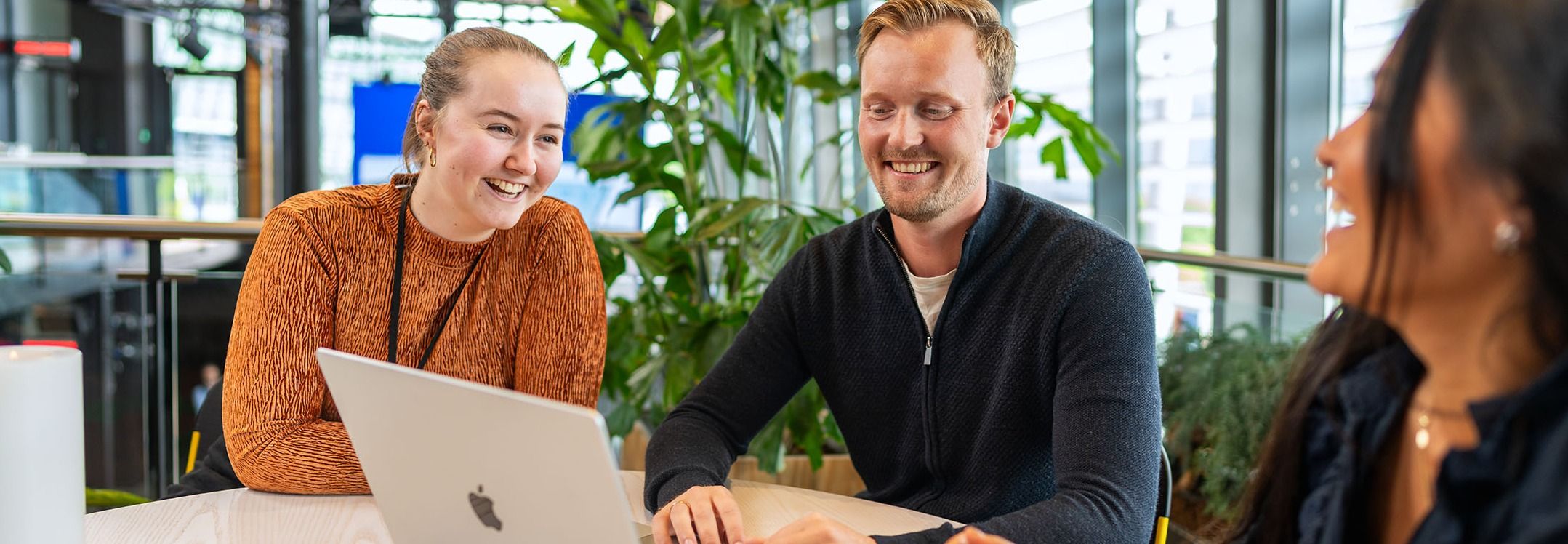 Tre personer ved et bord med laptop