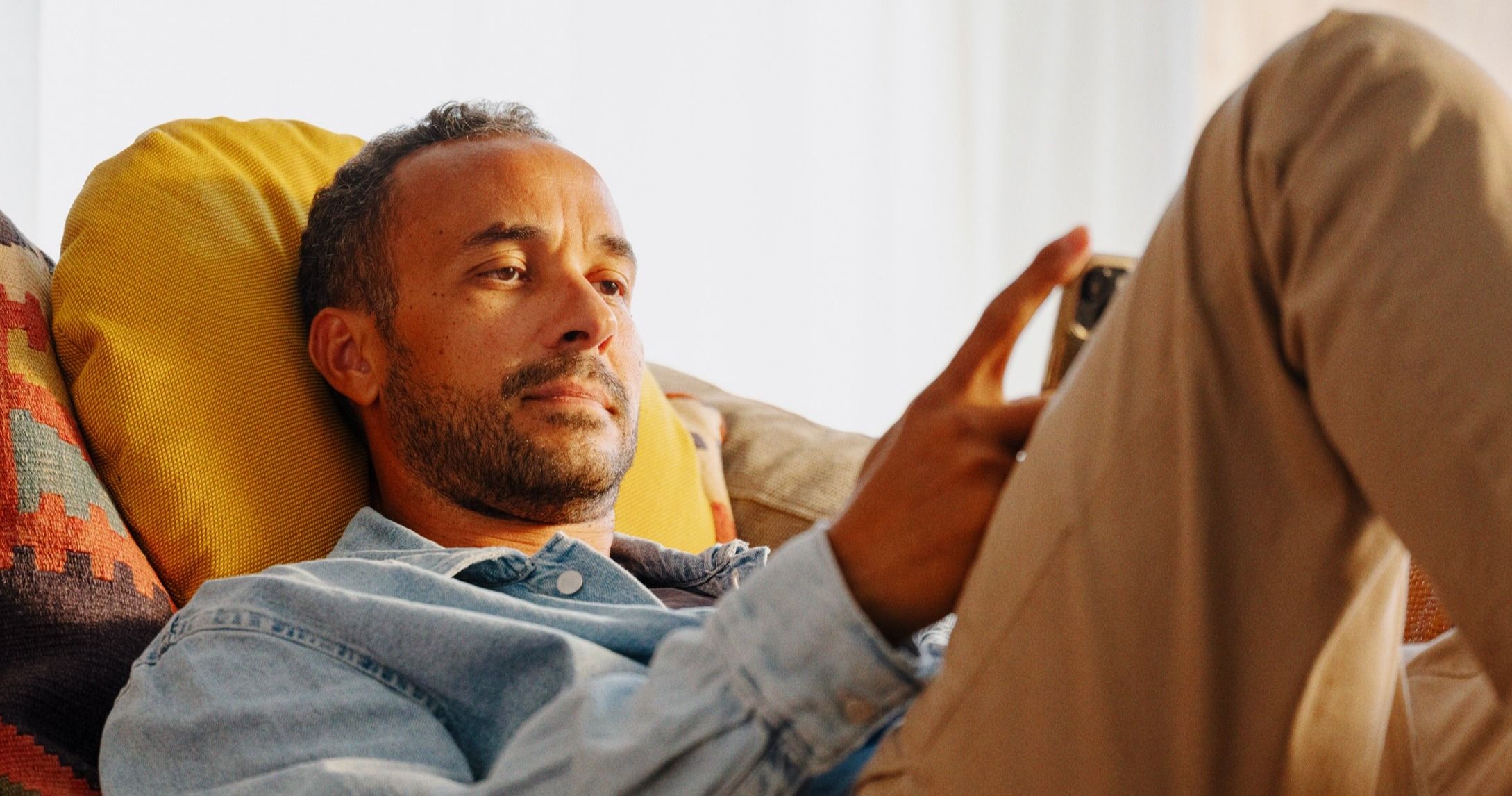 Person på sofa som er trygg på mobilen med SAFE