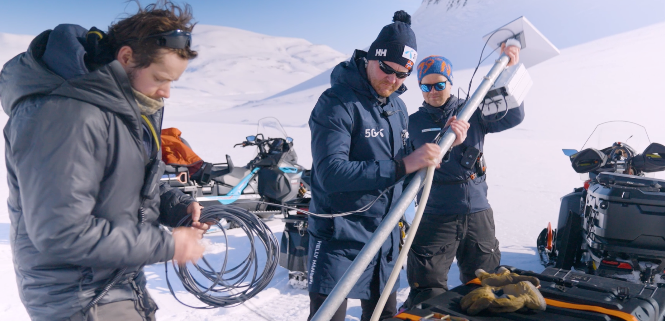 Mennesker installerer utstyr i snødekket landskap