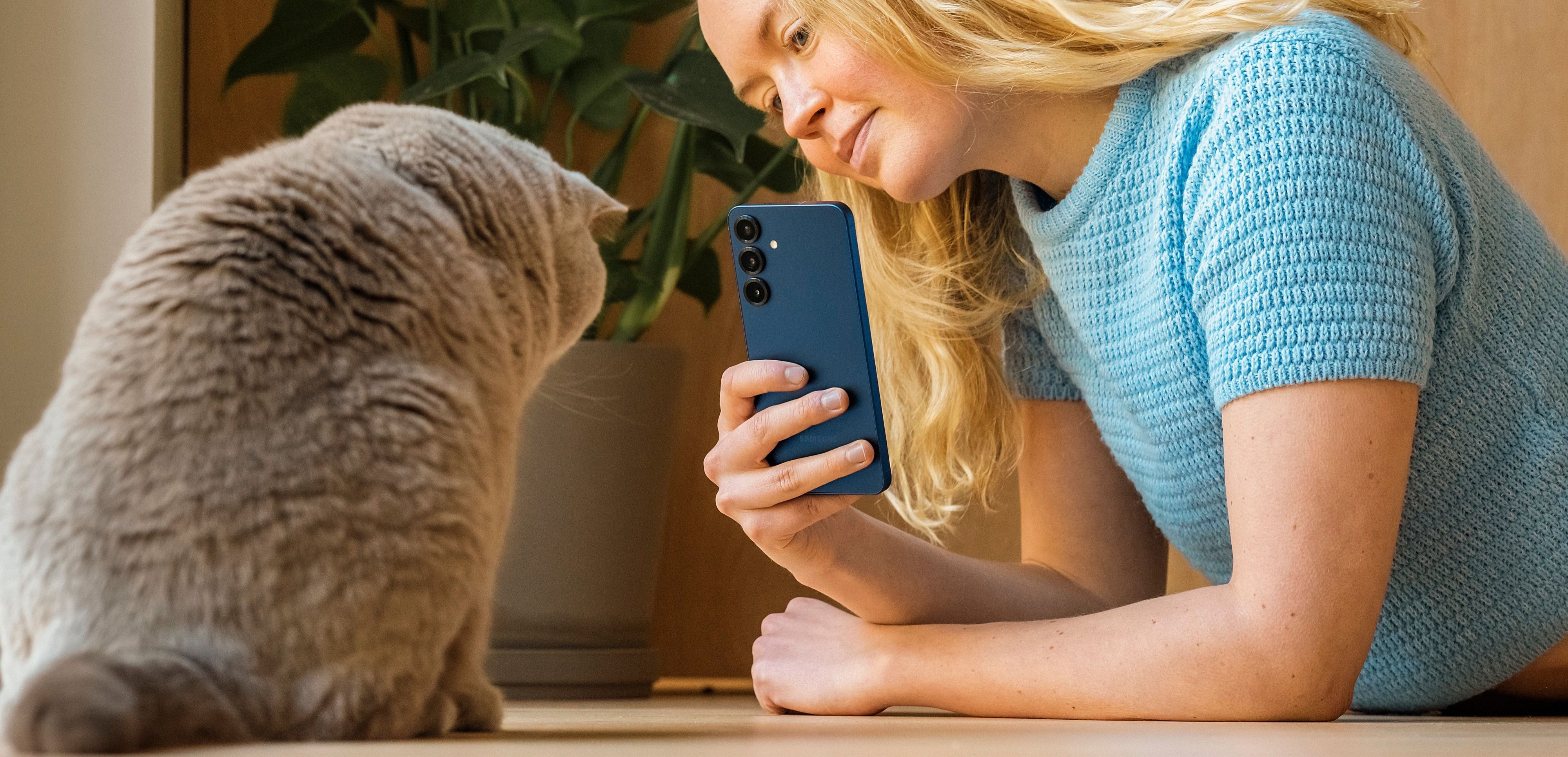 Dame som tar bilde av en katt med en Samsung S25