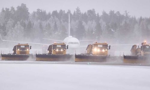 Brøytebiler på en snødekket flyplass