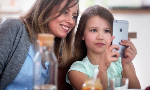 mor og datter med mobiltelefon