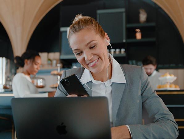 Dame som sitter på kafe og surfer på mobilen