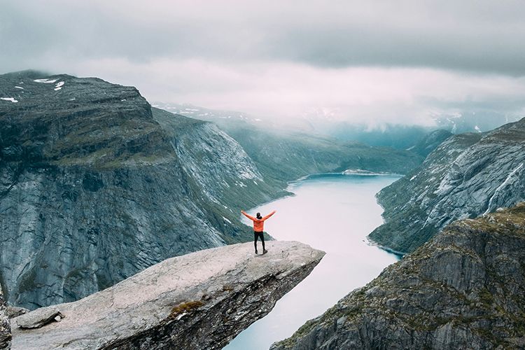 Kvinne på trolltunga som har høy hastighet i mobilabonnementet sitt