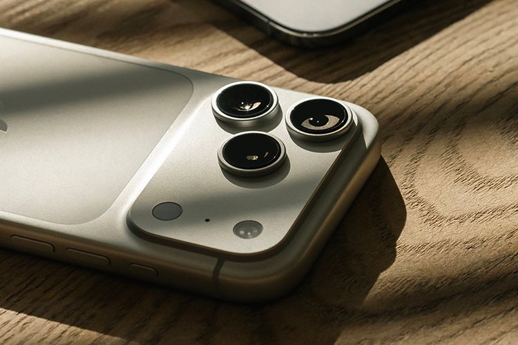 baksiden på den nye iphone 17 pro i fargen sølv på et bord i tre