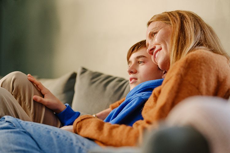 En familie samlet på kjøkkenet, med fokus på en nettbrett-aktivitet