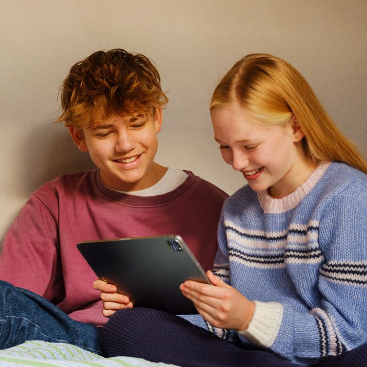 To personer ser på et nettbrett sammen