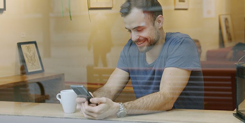 Mann surfer på mobil i artikkelen 5 myter om 5G