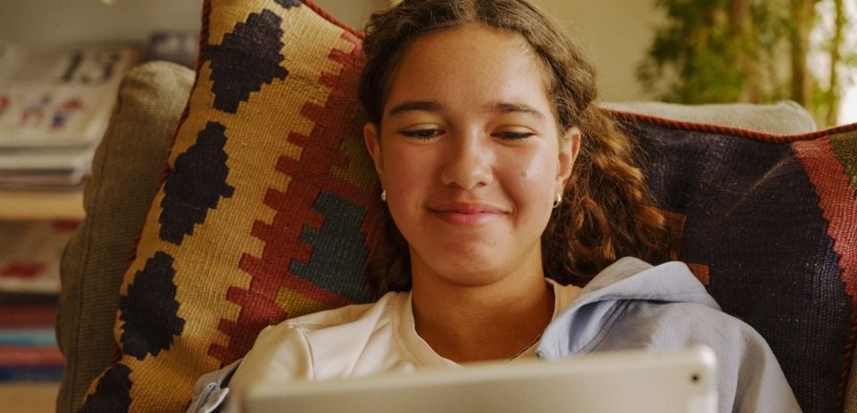 Tre personer i fargerike gensere sitter i en stue